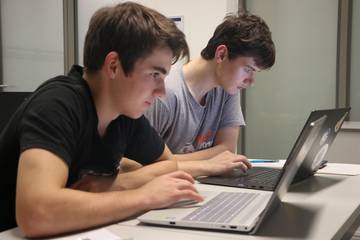 Two participants try their hands on challenging tasks during a contest.
